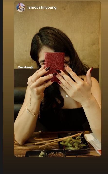 Customer holding a red Sora Kuro wallet